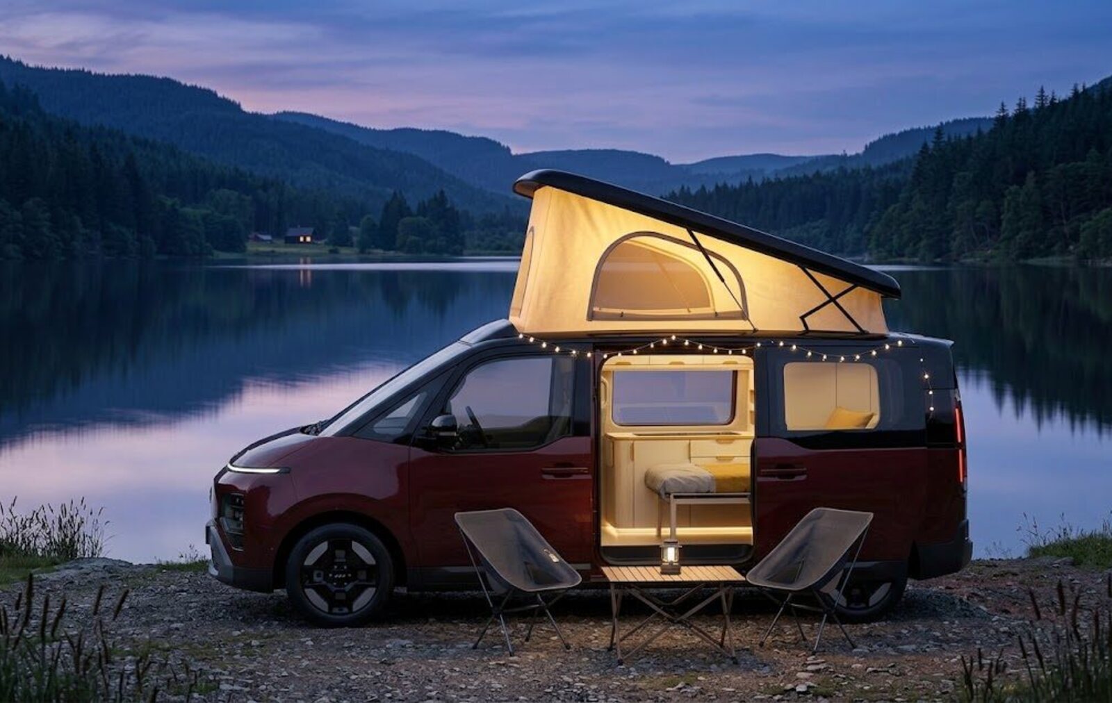 The Aurelis One at a lakeside camp at dusk, pop-top raised and the interior glowing